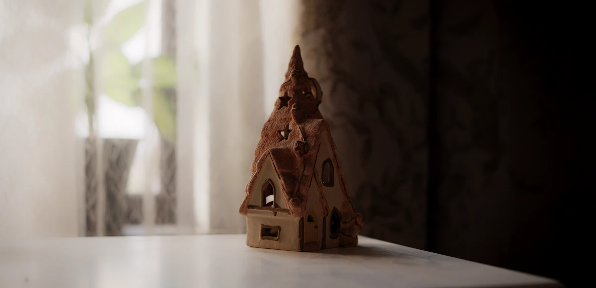 A detailed three-story Victorian dollhouse with painted walls and tiny handcrafted furniture inside