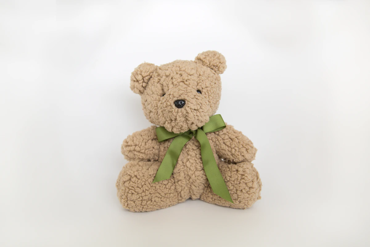 A soft and cuddly handmade teddy bear with an embroidered red scarf