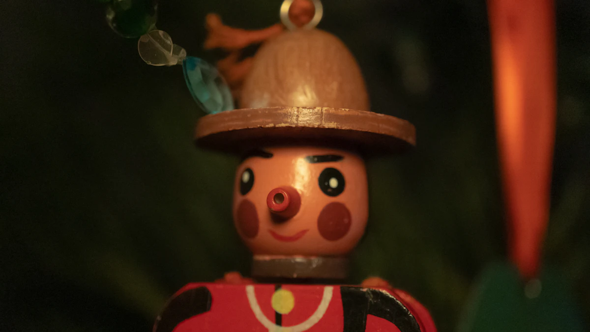 A tall hand-painted wooden nutcracker toy soldier in red and black with gold button details and a working jaw mechanism