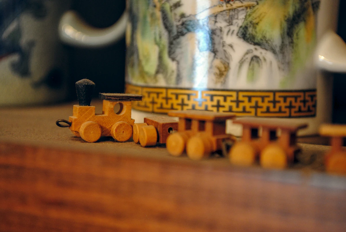 A beautifully hand-carved wooden toy train painted in red and green with brass details